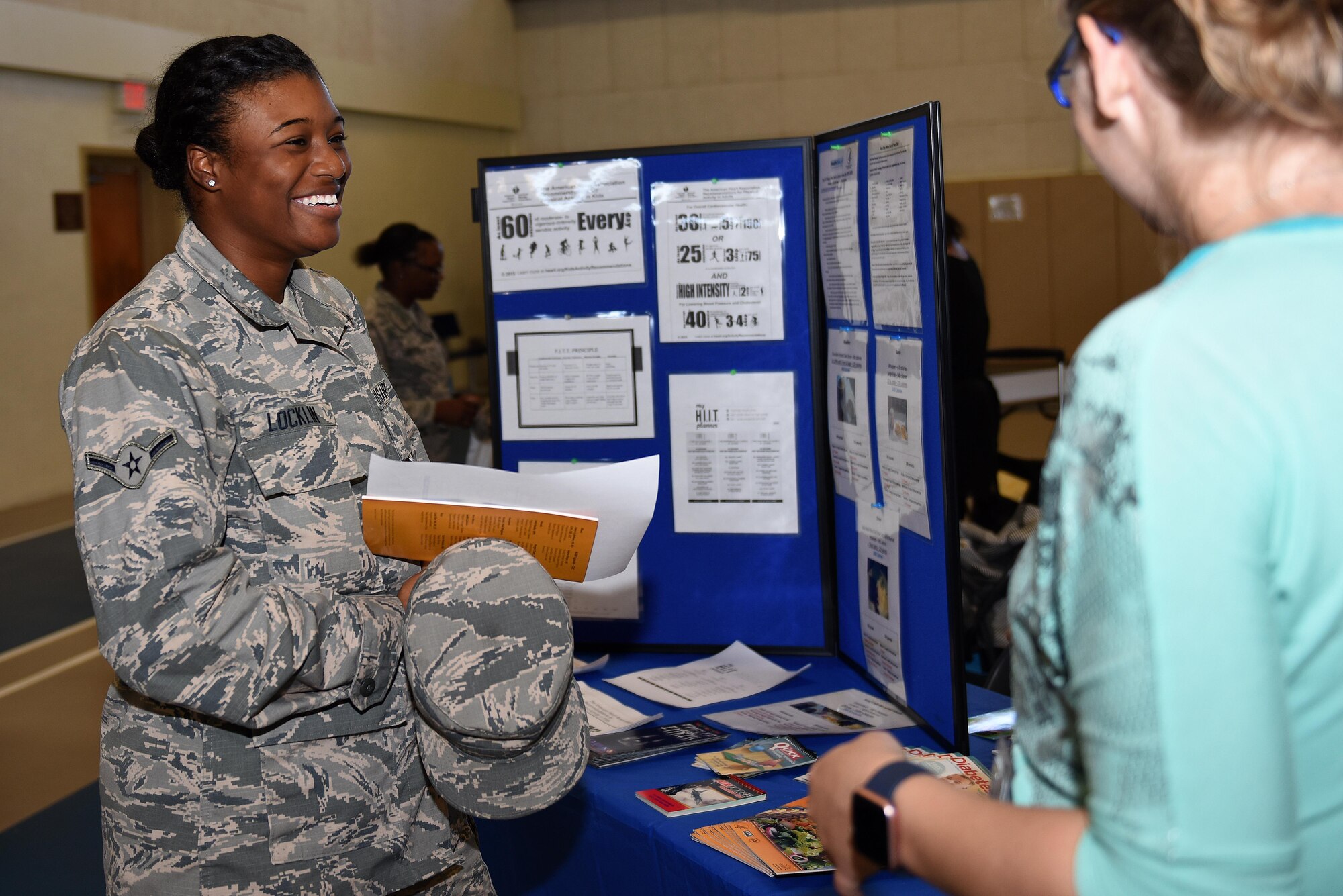 U.S. Air Force Airman Kelsey Locklin, 315th Training Squadron student, speaks to a representative during the Volunteer Fair at Carswell Fieldhouse on Goodfellow Air Force Base, Texas, Oct. 12, 2016. Locklin viewed a display for health, fitness and nutrition facts and references. (U.S. Air Force photo by Airman 1st Class Caelynn Ferguson/Released)