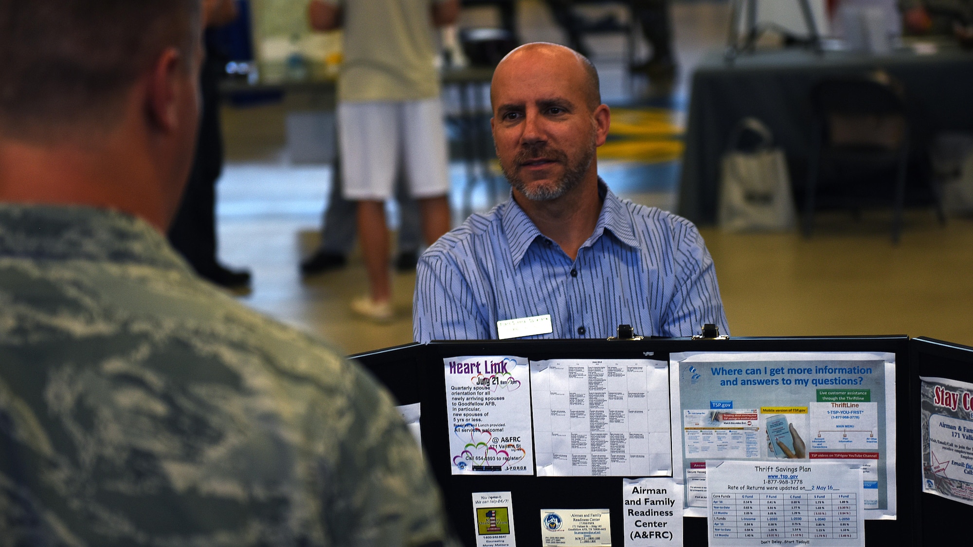 Brandon O’Neil, 17th Force Support Squadron Airman and Family Readiness Center work life consultant, speaks to listeners during the Volunteer Fair at Carswell Fieldhouse on Goodfellow Air Force Base, Texas, Oct. 12, 2016. O’Neil gave out financial counseling opportunities and information to people passing by the display. (U.S. Air Force photo by Airman 1st Class Caelynn Ferguson/Released)