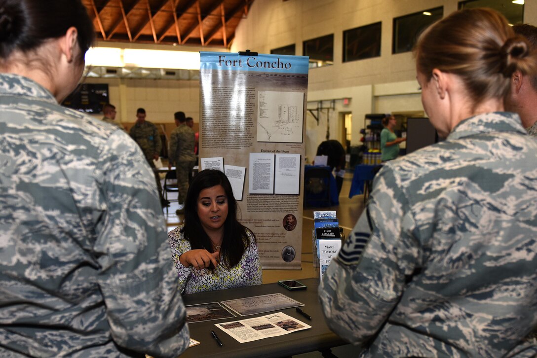 Airmen learn about Fort Concho events and volunteer opportunities at the Volunteer Fair at Carswell Fieldhouse on Goodfellow Air Force Base, Texas, Oct. 12, 2016. The Fort Concho display included events such as Halloween murder mysteries and ghost tours. (U.S. Air Force photo by Airman 1st Class Caelynn Ferguson/Released)