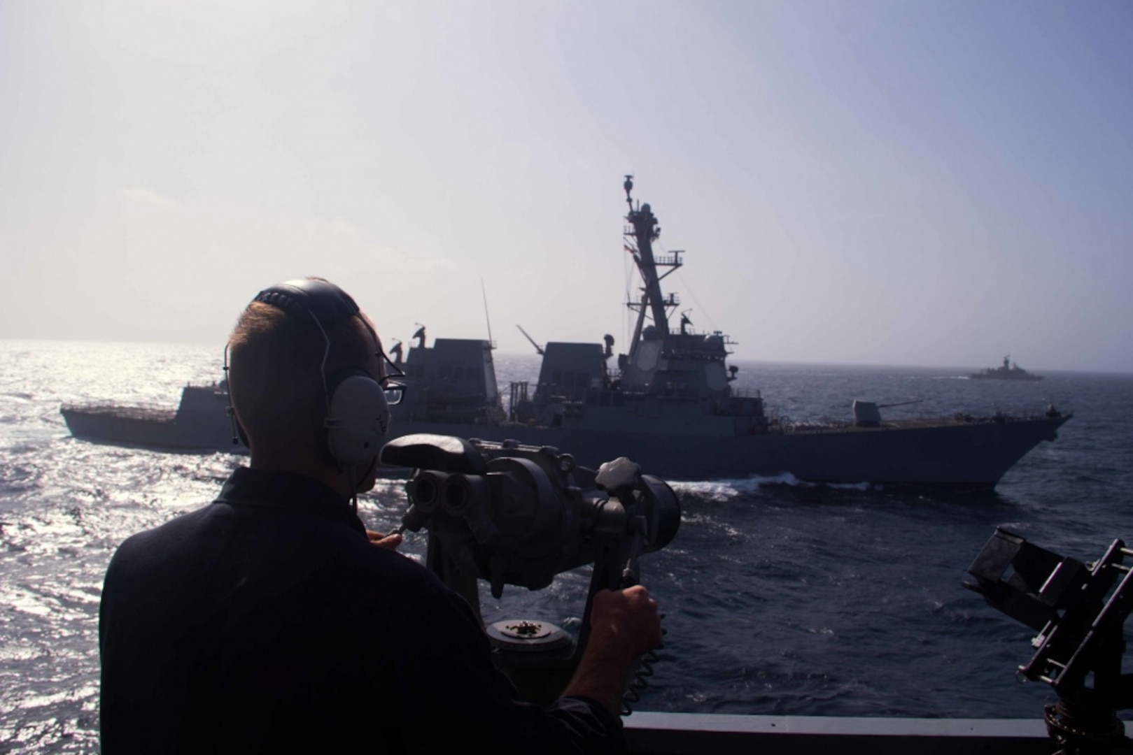 Navy Petty Officer 3rd Class Marcus Seaverns, from Norristown, Pa., scans for surface contacts on the port bridge wing of the guided missile destroyer USS Mason during an anti-submarine formation exercise with the guided missile destroyer USS Nitze, and Australian ships RFA Fort Victoria -- an auxiliary oiler replenishment ship -- and the frigate HMAS Perth, Aug. 28, 2016. Mason, deployed as part of the Eisenhower Carrier Strike Group, is supporting maritime security operations and theater security cooperation efforts in the U.S. 5th Fleet area of operations. Navy photo by Petty Officer 3rd Class Janweb B. Lagazo