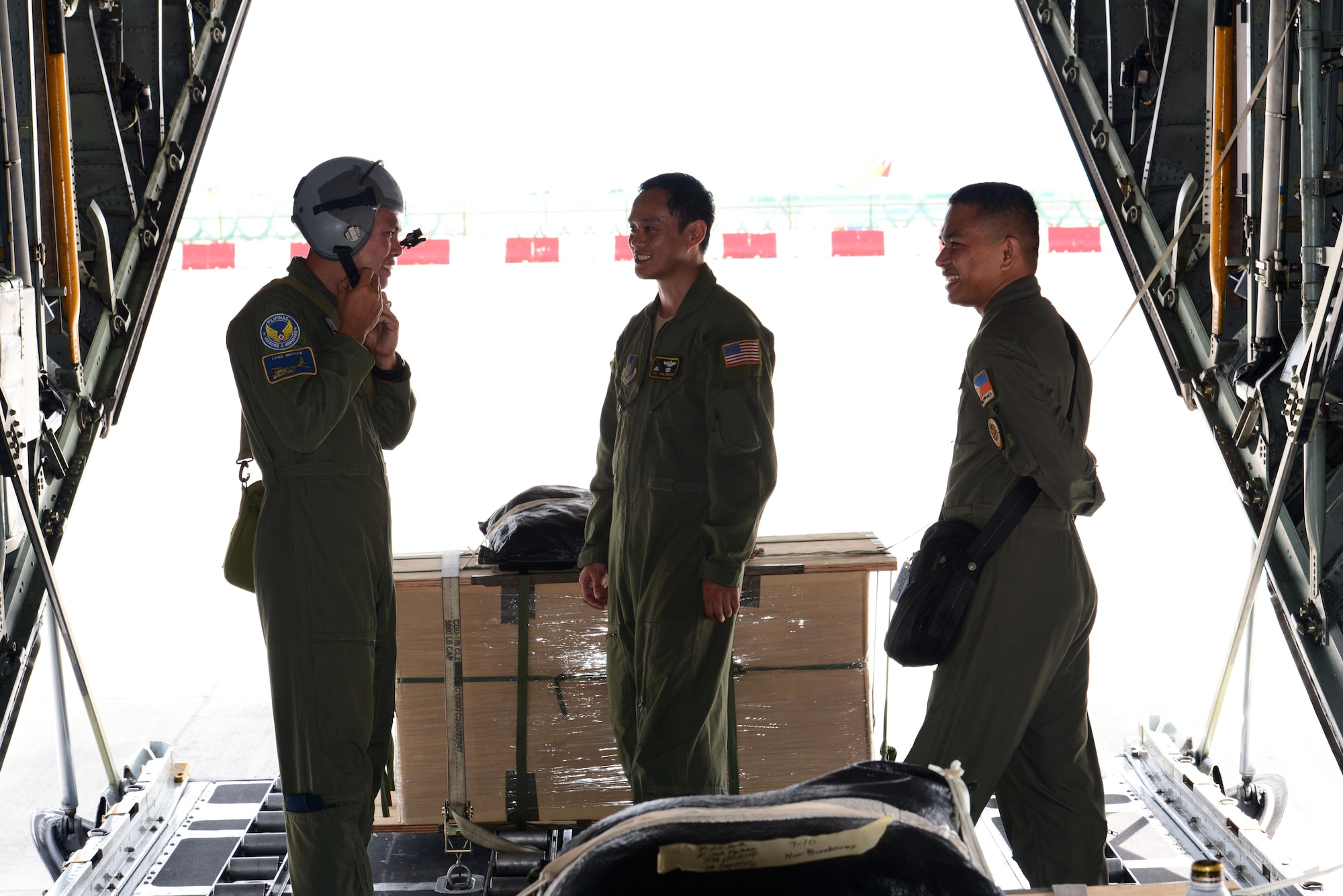 Philippine Air Force C-130 crew members prepare a U.S. Air Force C-130 Hercules aircraft for low-cost, low-altitude airdrop operations with U.S. Air Force Tech. Sgt. John Quiason (middle), 36th Airlift Squadron, 374th Airlift Wing, Yokota Air Base, Japan, during the current iteration of a rotational Air Contingent at Brigadier General Benito N Ebuen Air Base, Lapu-Lapu City, Philippines, Oct. 5, 2016. For the exchange, Yokota-based C-130s flew with members of the Philippine Air Force's 220th Airlift Wing, from Brig. Gen. Benito N. Ebuen Air Base, Lapu-Lapu City, Philippines, and discussed the intricacies of LCLA bundle drops. Two Yokota-based C-130s and crews, members of the 36th Contingency Response Group, Andersen Air Force Base, Guam, and other units from across U.S. Pacific Command conducted bilateral training missions and subject matter expert exchanges alongside their Philippine Air Force counterparts. The Air Contingent is helping build the capacity of the Philippine Air Force and increases joint training, promotes interoperability and provides greater and more transparent air and maritime situational awareness to ensure safety for military and civilian activities in international waters and airspace. Its missions include air and maritime domain awareness, personnel recovery, combating piracy, and assuring access to the air and maritime domains in accordance with international law. (U.S. Air Force photo by Capt. Mark Lazane)