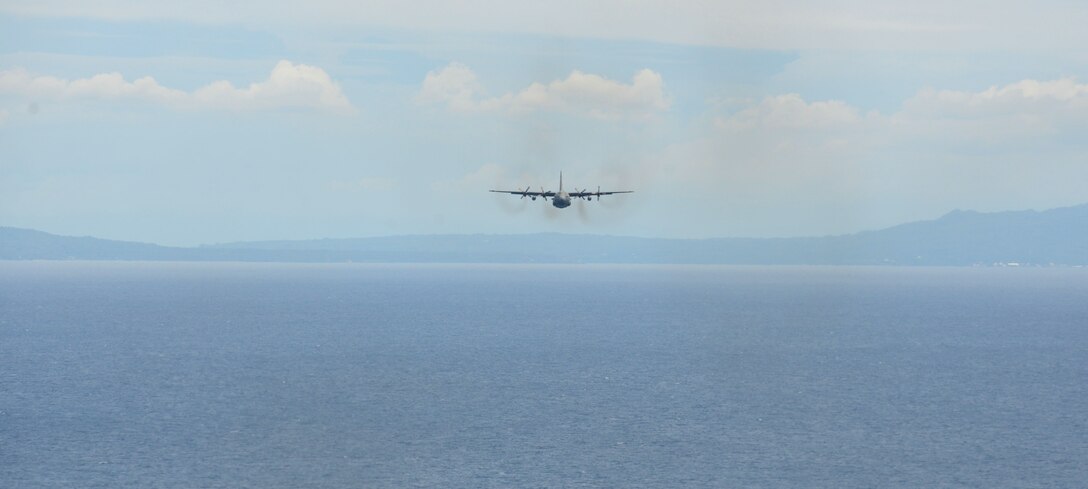 A U.S. Air Force C-130 Hercules participates in a low-cost, low-altitude bundle drop over the water near Cebu, Philippines, as part of the current iteration of a rotational Air Contingent at Brigadier General Benito N Ebuen Air Base, Lapu-Lapu City, Philippines, Oct. 5, 2016. For the exchange, C-130 aircraft from Yokota Air Base's 374th Airlift Wing flew with members of the Philippine Air Force's 220th Airlift Wing, from Brig. Gen. Benito N. Ebuen Air Base, Lapu-Lapu City, Philippines, and discussed the intricacies of LCLA bundle drops. Two Yokota-based C-130s, members of the 36th Contingency Response Group from Andersen Air Force Base, Guam, and other units from across U.S. Pacific Command conducted bilateral training missions and subject matter expert exchanges alongside their Philippine Air Force counterparts. The Air Contingent is helping build the capacity of the Philippine Air Force and increases joint training, promotes interoperability and provides greater and more transparent air and maritime situational awareness to ensure safety for military and civilian activities in international waters and airspace. Its missions include air and maritime domain awareness, personnel recovery, combating piracy, and assuring access to the air and maritime domains in accordance with international law. (U.S. Air Force photo by Capt. Mark Lazane)