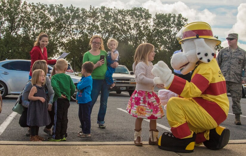 Sparky the Fire Dog, National Fire Protection Association official mascot, greets children during a Fire Prevention Week event at Joint Base Andrews, Md., Oct. 12, 2016. Families gathered during the event to learn about fire safety from the 11th Civil Engineer Squadron. Activities included coloring in educational books, touring the inside of a rapid intervention vehicle and running through fire response procedures. (U.S. Air Force Photo by Senior Airman Jordyn Fetter)