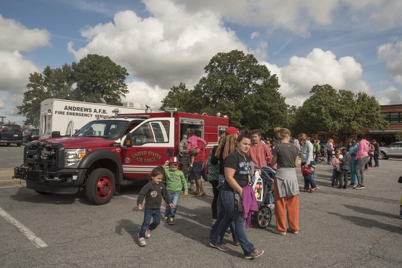 Participants of a Fire Prevention Week event line up to view the inside of a rapid intervention vehicle at Joint Base Andrews, Md., Oct. 12, 2016. Along with a brief about the vehicle, participants took part in a fire escape exercise and watched an emergency response demonstration. (U.S. Air Force Photo by Senior Airman Jordyn Fetter)