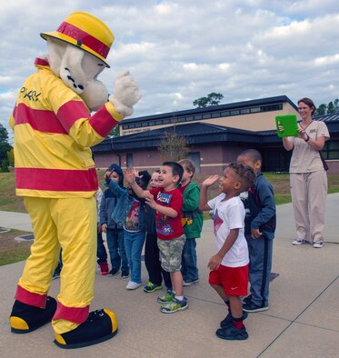Sparky the Dog dances while greeting a class of three-year-olds at the Child Development Center during Fire Prevention Week, Oct. 12, 2016, at Moody Air Force Base, Ga. During the visit, the children learned basic fire safety tips and had the chance to board a firetruck. (U.S. Air Force Photo by Airman 1st Class Greg Nash)