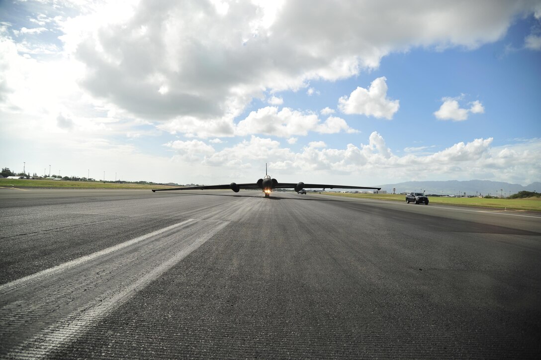 A U-2 Dragon Lady stops on the runway at Joint Base Pearl Harbor-Hickam (JBPHH), Hawaii, Oct. 3, 2016. The jet was met by an en route recovery team (ERT) from the 9th Aircraft Maintenance Squadron. Due to the bicycle-style landing gear, the U-2 tips to one side when it comes to a complete stop. Temporary-supporting wheels are placed under the wings by the ERT, allowing it to taxi. The U-2 is transitioning through JBPHH for the first time in over two years as it moves to and from Beale Air Force Base, California. This type of movement enables warfighters to provide vital intelligence to senior Air Force and civilian leaders. (U.S. Air Force photo by Tech. Sgt Aaron Oelrich/Released)