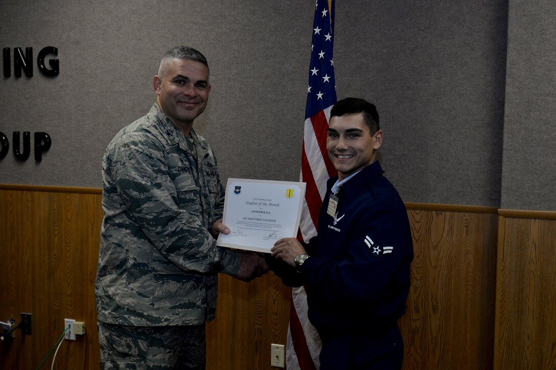 U.S. Air Force Col. Alex Ganster, 17th Training Group Commander, presents the 315th Training Squadron Enlisted Student of the Month award for September 2016 to Airman 1st Class Matthew Gillespie at Brandenburg Hall on Goodfellow Air Force Base, Texas, Oct. 7, 2016. (U.S. Air Force photo by Airman 1st Class Randall Moose/Released)