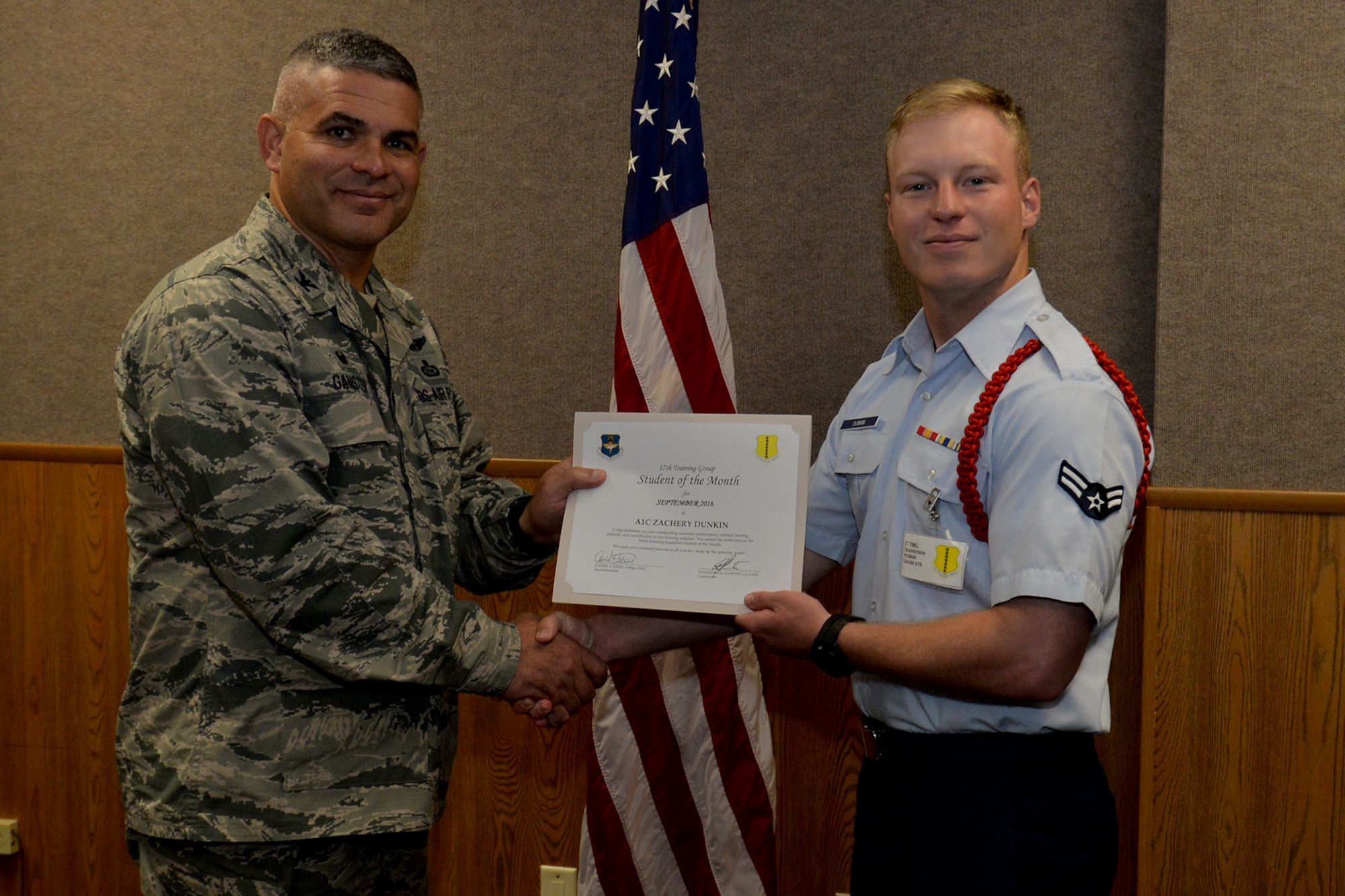 U.S. Air Force Col. Alex Ganster, 17th Training Group Commander, presents the 316th Training Squadron Student of the Month award for September 2016 to Airman 1st Class Zachery Dunkin at Brandenburg Hall on Goodfellow Air Force Base, Texas, Oct. 6, 2016. (U.S. Air Force photo by Airman 1st Class Randall Moose/Released)