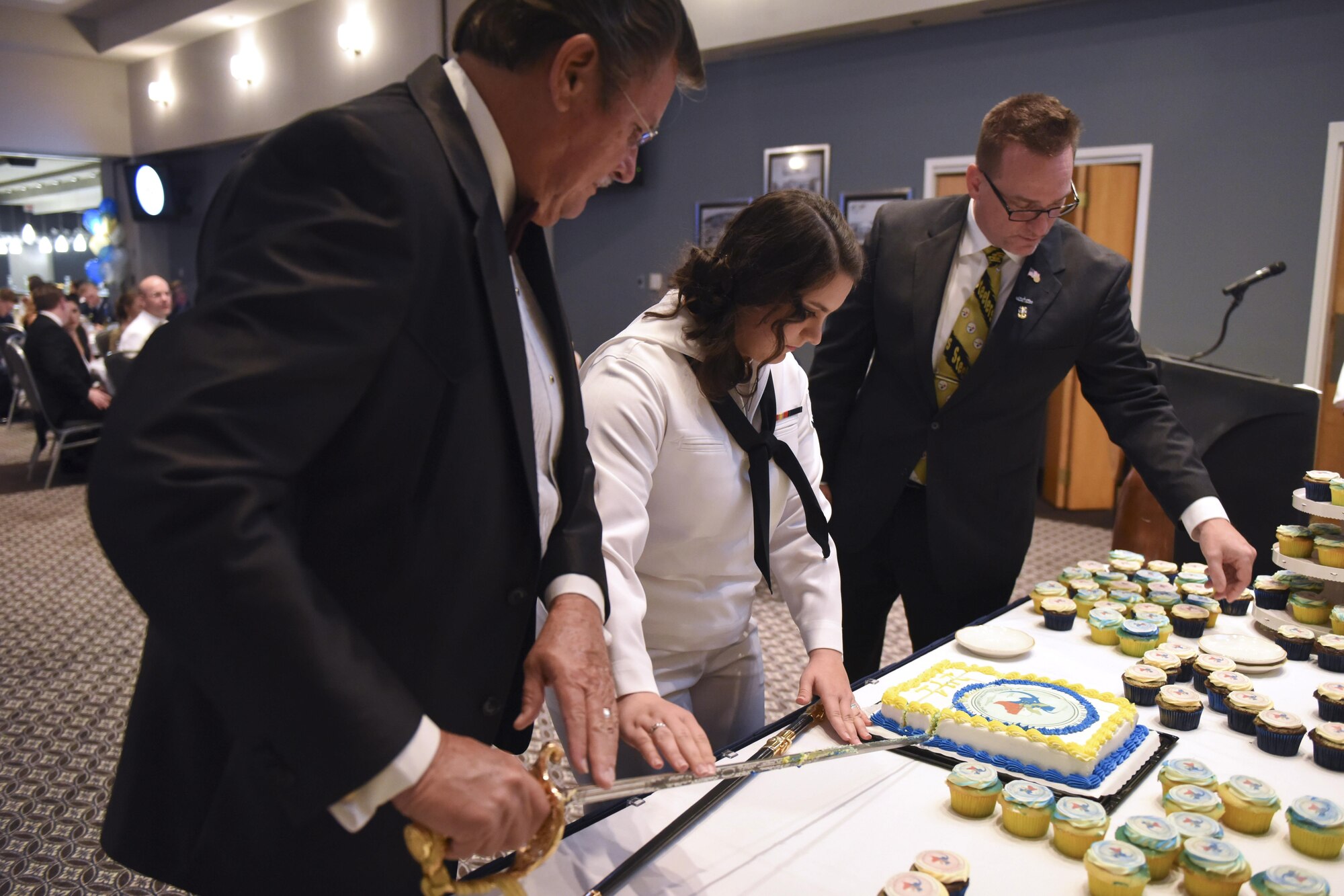 U.S. Navy Retired Master Chief Petty Officer Sean Lemmons, Petty Officer 3rd Class Caitlin Snow, Center for Information Warfare Training Detachment Goodfellow student and retired Master Chief Petty Officer Jerry Marlett cut the Navy’s 241st birthday cake at the Event Center on Goodfellow Air Force Base, Texas, Oct. 7, 2016. The cutting of the cake by the oldest and youngest sailor is a long held tradition. (U.S. Air Force photo by Airman 1st Class Chase Sousa/Released)