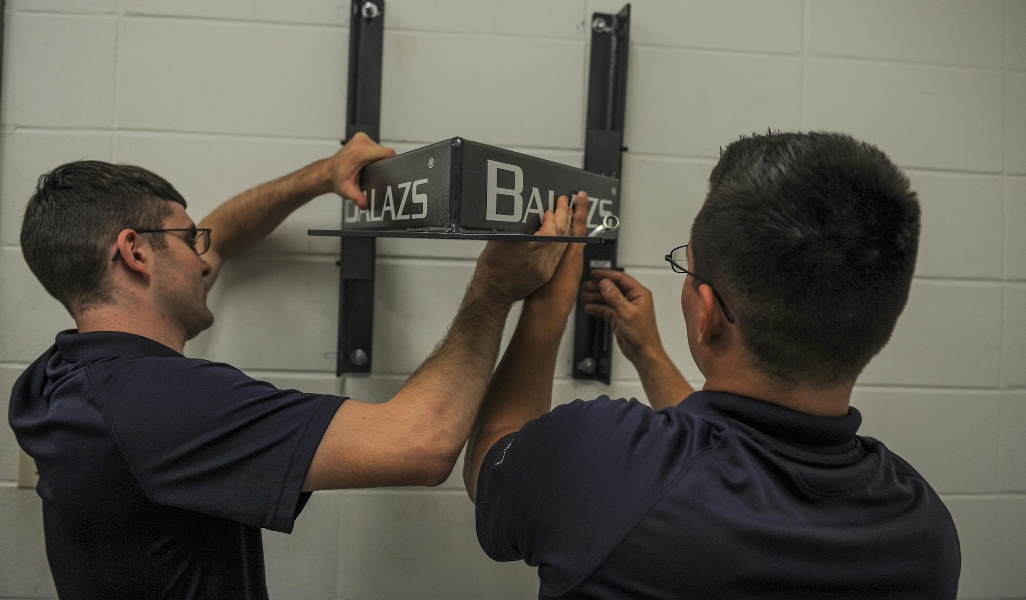 Staff Sgt. Michael Olaughlin,left, and Senior Airman Robert Stark, fitness specialists with the 1st Special Operations Force Support Squadron, set up a speed bag in the Aderholt Fitness Center at Hurlburt Field, Fla., Oct. 11, 2016. The primary duty of a fitness specialist is to assist Airmen and families in being able to work out with proper form and ensure Air Commandos are using the equipment correctly. (U.S. Air Force photo by Airman 1st Class Isaac O. Guest IV)