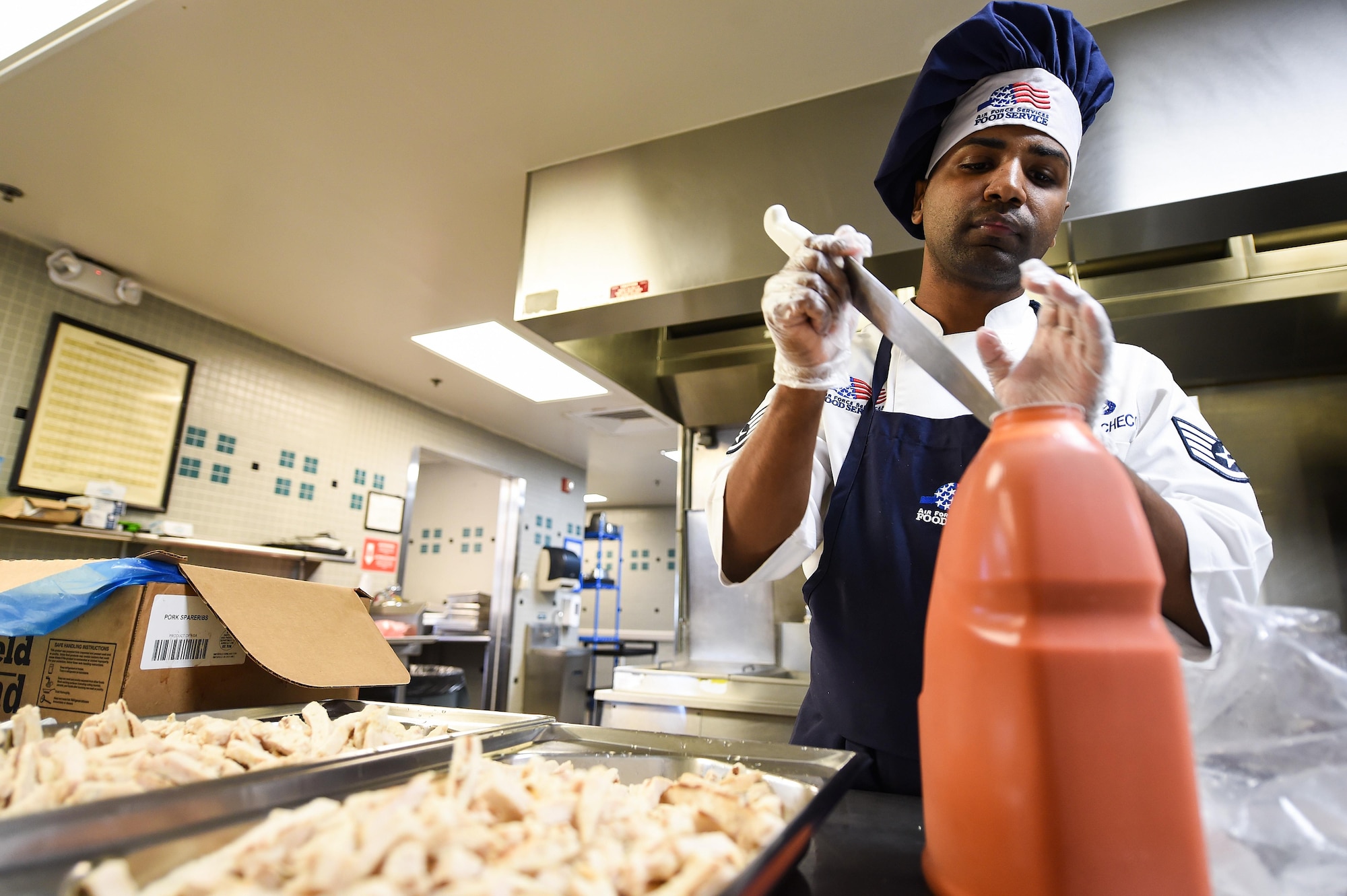 Staff. Sgt. Raymond Soto-Pacheco, a food shift supervisor with the 1st Special Operations Force Support Squadron, opens a bottle of buffalo sauce at the Reef dining facility on Hurlburt Field, Fla., Oct. 13, 2016. The Reef is the only buffet style dining facility in the Air Force and serves roughly 400 Air Commandos a day. (U.S. Air Force photo by Senior Airman Jeff Parkinson)