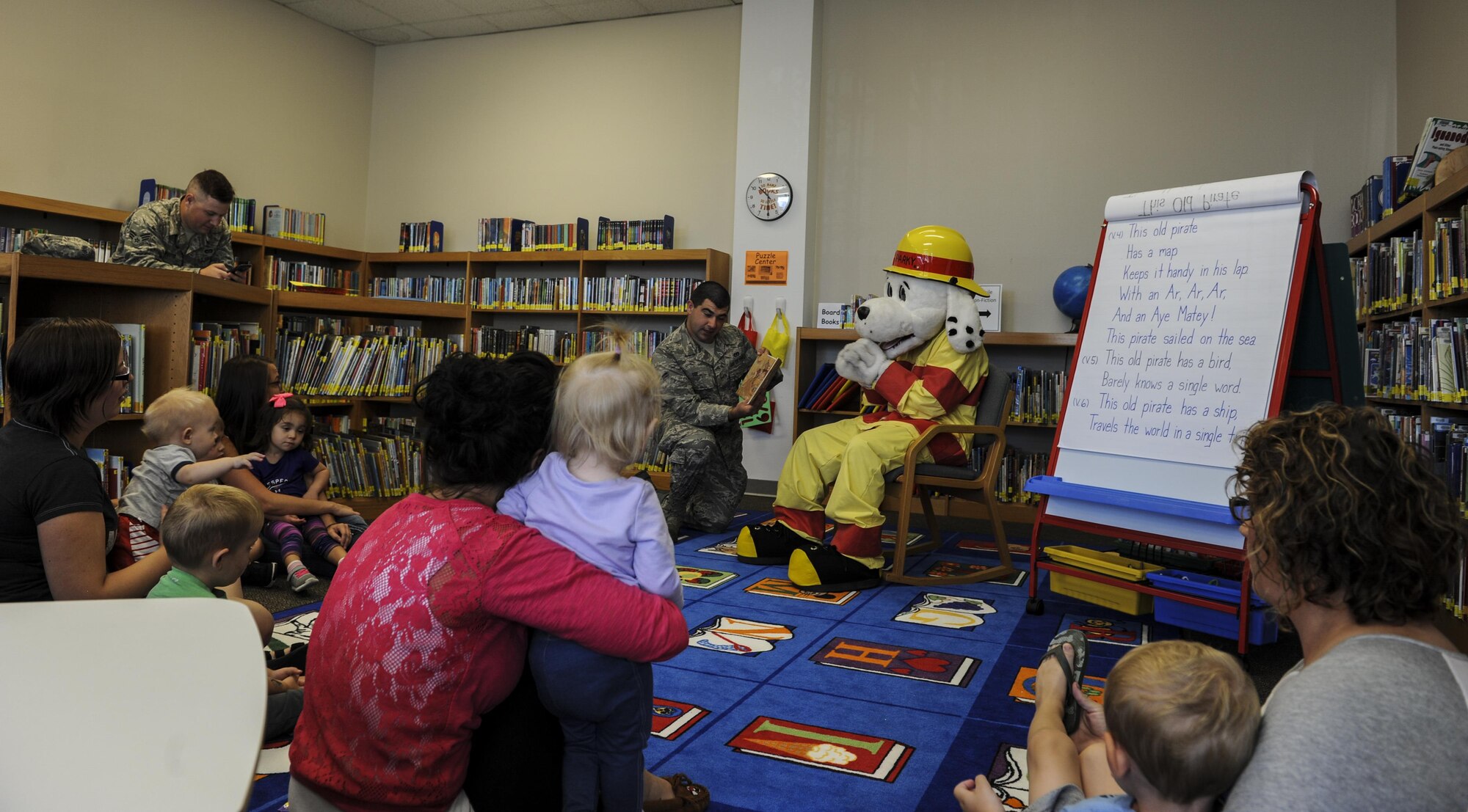 Airman 1st Class Kevin See, a firefighter with the 1st Special Operations Civil Engineer Squadron Fire Department, and “Sparky the Fire Dog,” the National Fire Prevention Association mascot, read to children for story time at the library on Hurlburt Field, Fla., Oct. 13, 2016.  The 1st SOCES Fire Department and Sparky visited Child Development Centers, the base library and other locations throughout the week to educate Airmen and raise awareness about fire prevention. (U.S. Air Force photo by Airman 1st Class Isaac O. Guest IV)