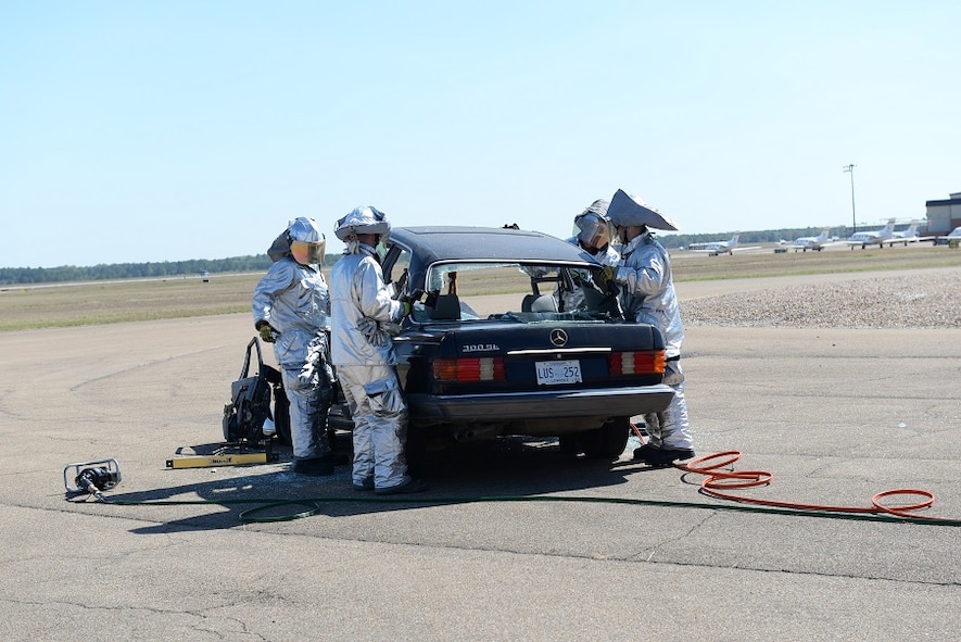 Firefighters use their tools to perform a vehicle extrication by removing the roof of a sedan Oct. 8, 2016, during the Fire Prevention Week open house at Columbus Air Force Base, Mississippi. Rather than remove the injured from the vehicle, firefighters are trained to remove the vehicle from the injured victim. (U.S. Air Force photo by Airman 1st Class John Day)