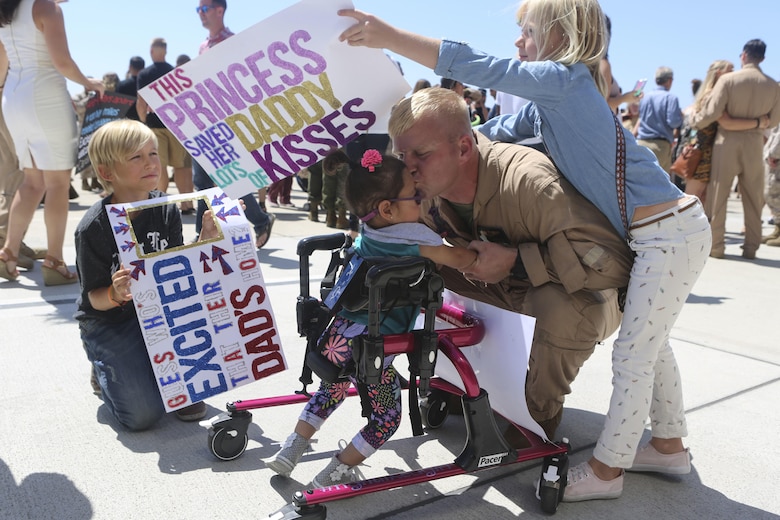 Gunnery. Sgt. Travis Borkowski, crew chief with Marine Medium Tiltrotor Squadron (VMM) 166, reunites with his family after returning from a deployment with the 13th Marine Expeditionary Unit aboard Marine Corps Air Station Miramar, Calif., Sept. 10. During his deployment, Borkowski and his wife Megan officially adopted Briella after fostering her for almost two years. (U.S. Marine Corps photo by Lance Cpl. Harley Robinson/Released)