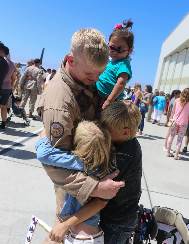 Gunnery Sgt. Travis Borkowski, a crew chief with Marine Medium Tiltrotor Squadron (VMM) 166, reunites with his family during a homecoming ceremony for the aviation combat element of the 13th Marine Expeditionary Unit aboard Marine Corps Air Station Miramar, Calif., Sept. 10. During his deployment, Borkowski and his wife Megan officially adopted Briella Borkowski after fostering her for almost two years. (U.S. Marine Corps photo by Lance Cpl. Harley Robinson/Released)