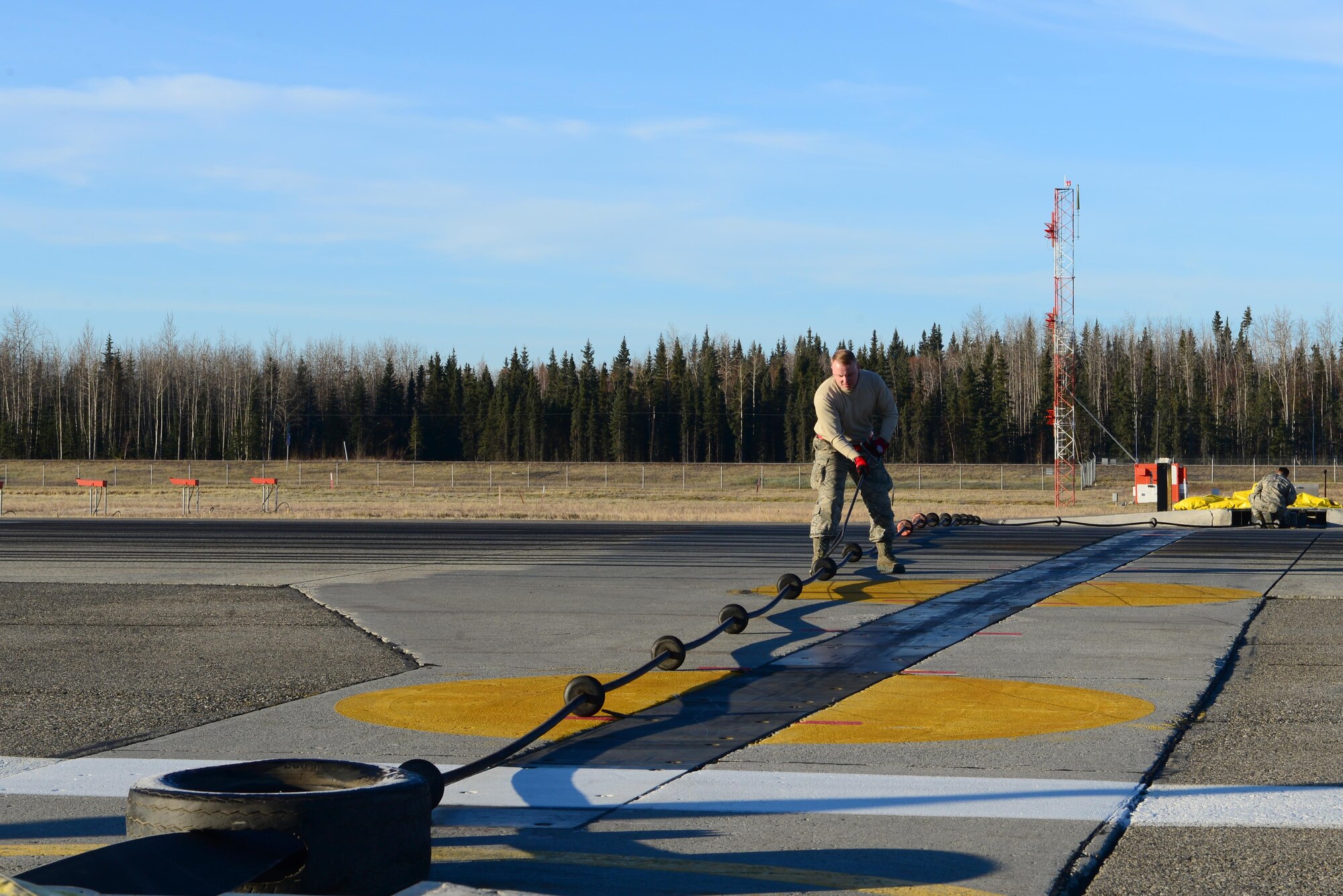 U.S. Air Force Senior Airman Cody Hall, a 354th Civil Engineer Squadron power production technician, prepares to put tension on a barrier Oct. 12, 2016, at Eielson Air Force Base, Alaska. The power production flight puts these barriers up every time aircraft take off from the runway to ensure safety in case of an in-flight emergency. (U.S. Air Force photo by Airman 1st Class Cassandra Whitman)
