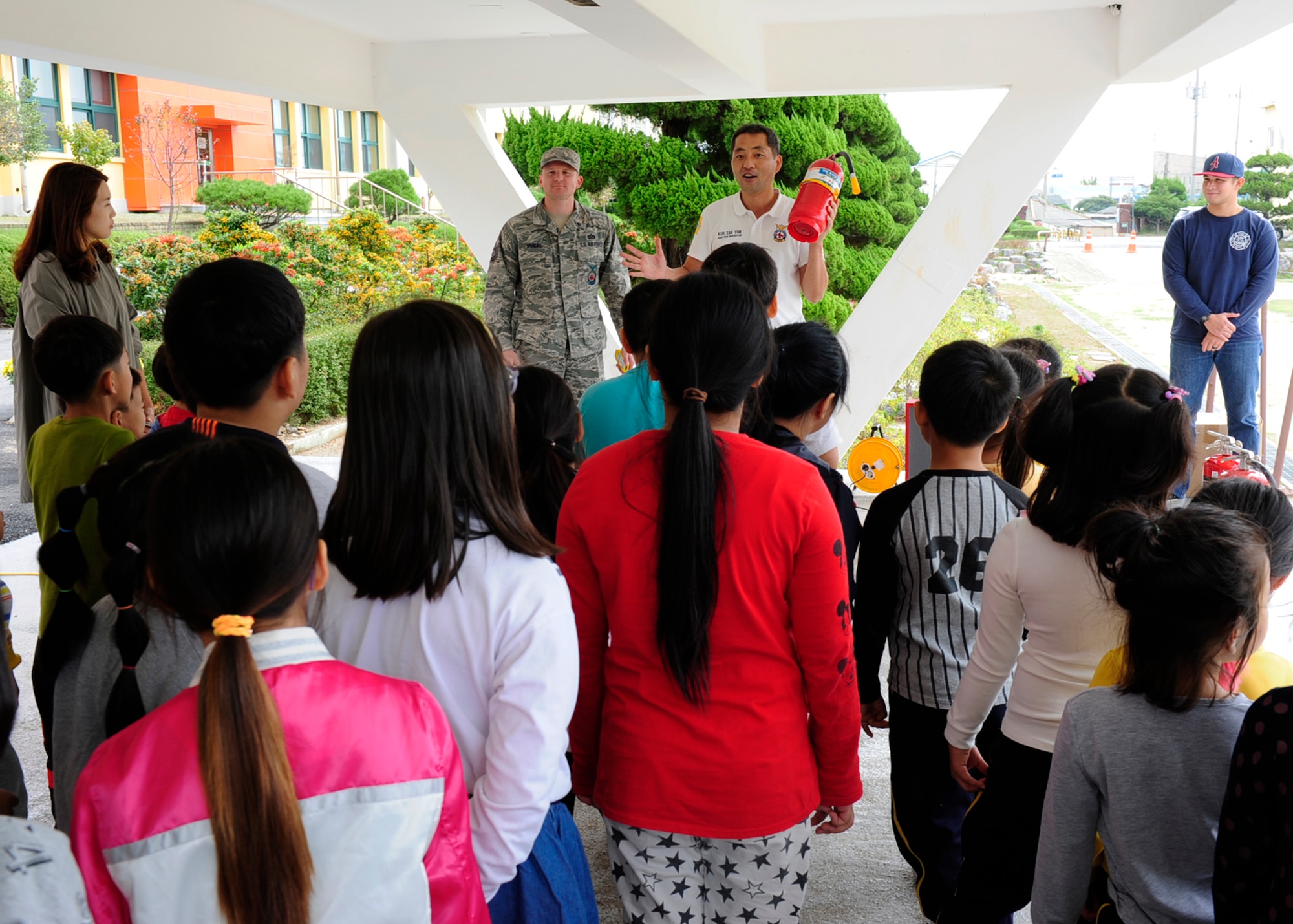Firefighters from the 8th Civil Engineer Squadron, talk with a group of children about how to extinguish a fire while visiting Okbong Elementary School, Gunsan, Republic of Korea, Oct. 13, 2016. The visit was part of the 2016 Fire Prevention Week campaign, which will run from Oct. 9-15. This year’s theme is “Don’t Wait – Check the Date! Replace Smoke Alarms Every 10 Years.” (U.S. Air Force photo by Staff Sgt. Chelsea Browning/Released)