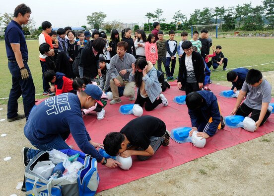 Firefighters from the 8th Civil Engineer Squadron, teach a group of children how to perform cardiopulmonary resuscitation while visiting Okbong Elementary School, Gunsan, Republic of Korea, Oct. 13, 2016. The visit was part of the 2016 Fire Prevention Week campaign, which will run from Oct. 9-15. This year’s theme is “Don’t Wait – Check the Date! Replace Smoke Alarms Every 10 Years.” (U.S. Air Force photo by Staff Sgt. Chelsea Browning/Released)