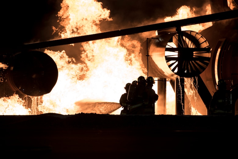 U.S service members battle flames during a simulated aircraft crash burn at Misawa Air Base, Japan, Oct. 12, 2016. The burn, performed by four distinguished visitors, allowed members to experience the processess and challenges that come with fighting an aircraft fire. The DVs were both U.S. Air Force and Navy personnel. As a part of Misawa's Fire Prevention Week, families and other miltary members came and spectated. (U.S. Air Force photo by Airman 1st Class Sadie Colbert)