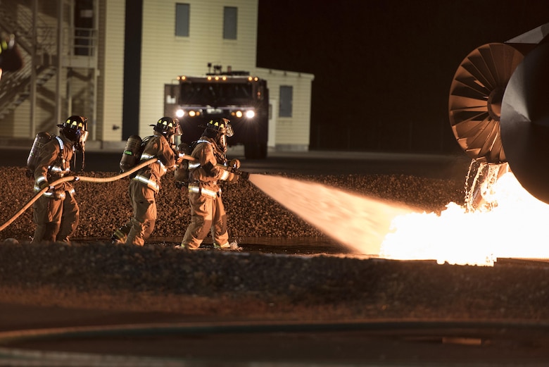 U.S. service members battle flames during a simulated aircraft crash burn at Misawa Air Base, Japan, Oct. 12, 2016. Children were able to meet with firefighters after the event as a part of Misawa's Fire Prevention Week. Fire prevention week also included events such as static displays of firetrucks on a separate day open to all of the community. (U.S. Air Force photo by Airman 1st Class Sadie Colbert)
