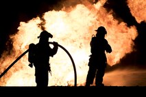 Airmen with the 35th Civil Engineer Squadron fire department steady a hose line to fight a simulated fire at Misawa Air Base, Japan, Oct. 12, 2016. The firehoses connect to firetrucks, which hold up to 3,000 gallons of water per truck. Once water is depleted, firefighters desconnect hoses and hook them up to nearby fire hydrants, enabling firefighters to battle flames. (U.S. Air Force photo by Airman 1st Class Sadie Colbert)