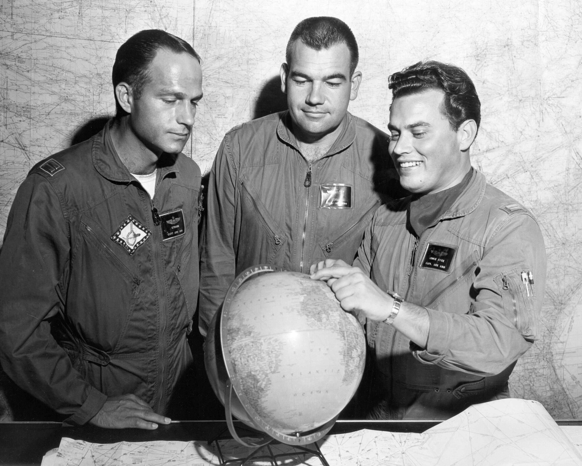 From left, Capt. Billy Strang, Maj. Otto Doville and Capt. Bruce Fite point to a location in Europe on the globe. (Courtesy photo)