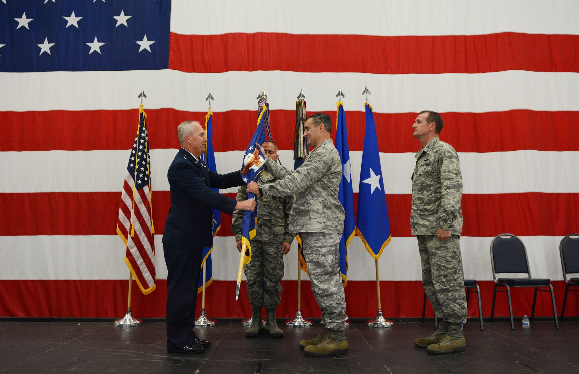 Maj. Gen. Donald P. Dunbar, Wisconsin adjutant general, passed the flag to Col. Erik Peterson, 115th Fighter Wing commander, during a wing change of command ceremony in hangar 406 Oct. 1, 2016. Airmen from the 115 FW attended the event to watch Col. Jeffrey J. Wiegand, former 115 FW commander, relinquish his command to Peterson. (U.S. Air National Guard photo by Staff Sgt. Kyle Russell)