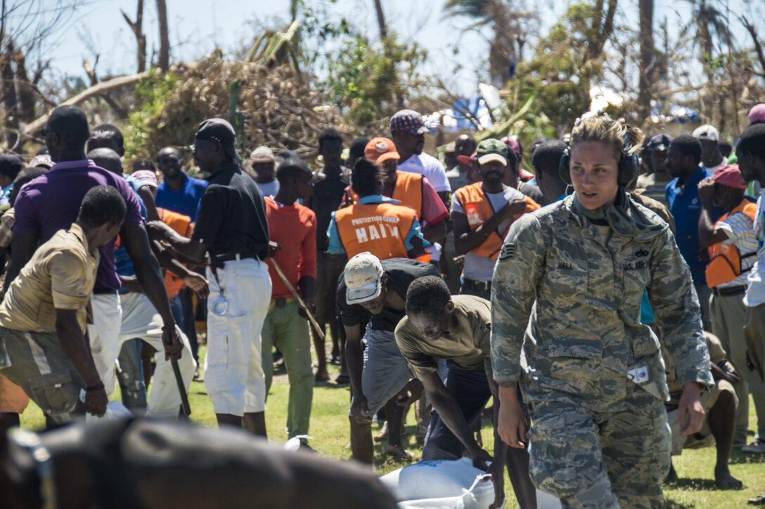 Air Force Staff Sgt. Jessie Hall offloads food to the survivors of Hurricane Matthew in Dame Marie, Haiti, Oct. 12th, 2016. Hall is assigned to the 621st Contingency Response Wing, which is helping Joint Task Force Matthew support Haiti's request for humanitarian assistance. Air Force photo by Staff Sgt. Robert Waggoner