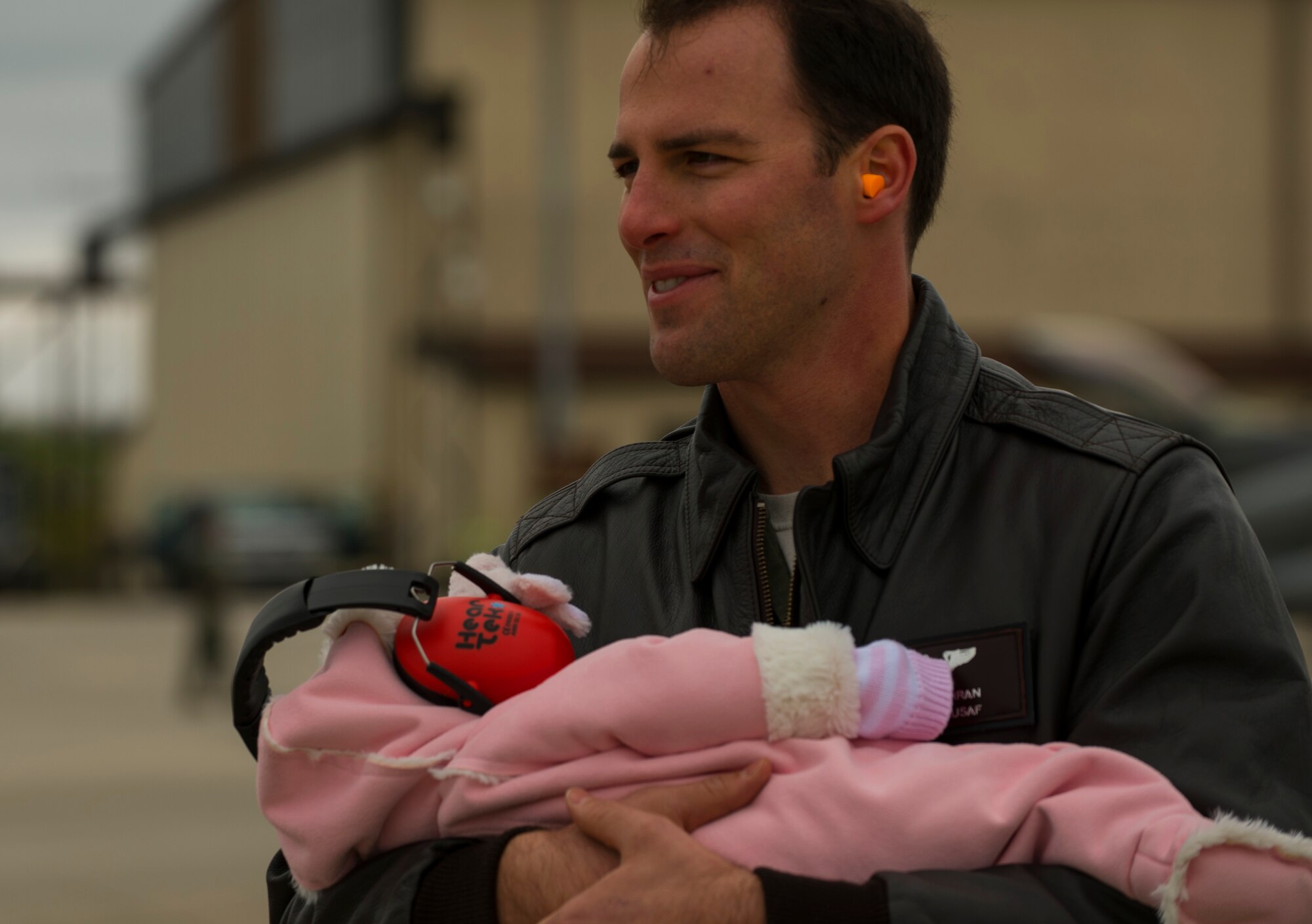 An Airman assigned to the 52nd Fighter Wing cradles an infant while waiting to greet returning Airmen on the flightline at Spangdahlem Air Base, Germany, Oct. 6, 2016. Approximately 300 of the 480th Expeditionary Fighter Squadron’s Airmen, who serve in flight, maintenance or support roles for the F-16 Fighting Falcon fighter aircraft, completed a six-month deployment to Southwest Asia by providing close air support and dynamic targeting operations in support of Operation Inherent Resolve. (U.S. Air Force photo by Senior Airman Dawn M. Weber)