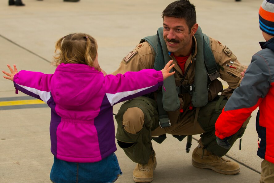 An Airman from the 480th Expeditionary Fighter Squadron greets his daughter on the flightline at Spangdahlem Air Base, Germany, Oct. 6, 2016. Approximately 300 Airmen reunited with their families and friends after a six-month deployment to Southwest Asia in support of Operation Inherent Resolve. (U.S. Air Force photo by Senior Airman Dawn M. Weber)