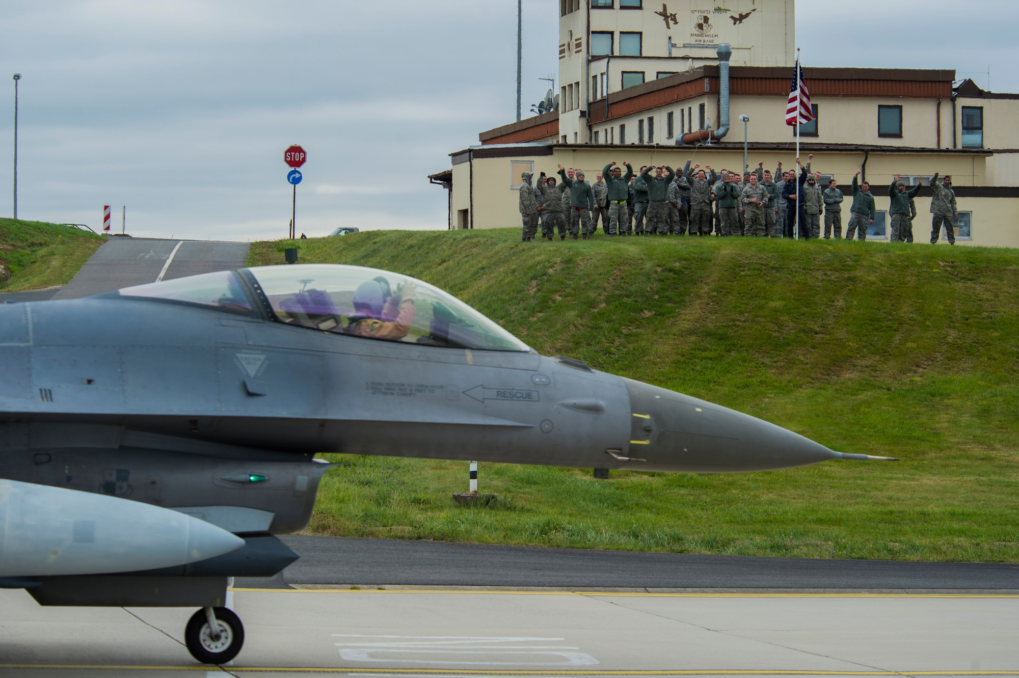 Airmen assigned to the 52nd Fighter Wing wave as an F-16 Fighting Falcon fighter aircraft pilot assigned to the 480th Expeditionary Fighter Squadron during the squadron’s return to Spangdahlem Air Base, Germany, Oct. 6, 2016. Approximately 300 of the Airmen, who serve in flight, maintenance or support roles for the F-16, completed a six-month deployment to Southwest Asia by providing close air support and dynamic targeting operations as part of the squadron’s first deployment in support of Operation Inherent Resolve. Operation Inherent Resolve aims to eliminate the Da'esh terrorist group and the threat they pose to Iraq, Syria and the wider international community. (U.S. Air Force photo by Staff Sgt. Joe W. McFadden)