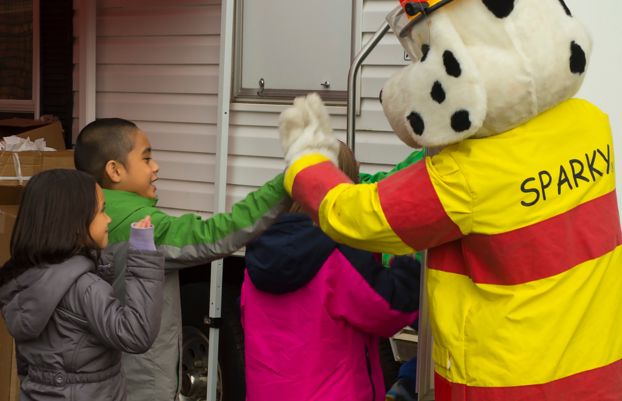 Sparky, 52nd Civil Engineer Squadron firefighters’ mascot, high-fives students during a visit at Spangdahlem Elementary School on Spangdahlem Air Base, Germany, Oct. 12, 2016. The firefighters demonstrated the importance of fire safety to students in observance of Fire Prevention Week. (U.S. Air Force photo by Senior Airman Dawn M. Weber)