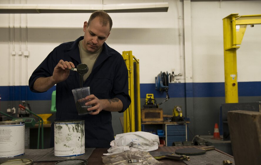 Staff Sgt. Kyle Morris, 435th Construction and Training Squadron aircraft arresting systems depot technician, mixes paint at Ramstein Air Base, Germany, Oct. 13, 2016. Morris mixed the paint to spray over dents and chips on a BAK-12 aircraft arresting system during an overhaul. The 435th CTS is the only squadron within U.S. Air Forces in Europe with the capability to overhaul the systems. (U.S. Air Force photo by Senior Airman Tryphena Mayhugh)