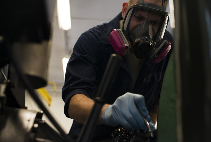 Staff Sgt. Kyle Morris, 435th Construction and Training Squadron aircraft arresting systems depot technician, sprays paint on a BAK-12 aircraft arresting system at Ramstein Air Base, Germany, Oct. 12, 2016. The systems decelerate aircraft during landing and require an overhaul every ten years. The 435th CTS overhauls all aircraft arresting systems within U.S Air Forces in Europe. (U.S. Air Force photo by Senior Airman Tryphena Mayhugh)