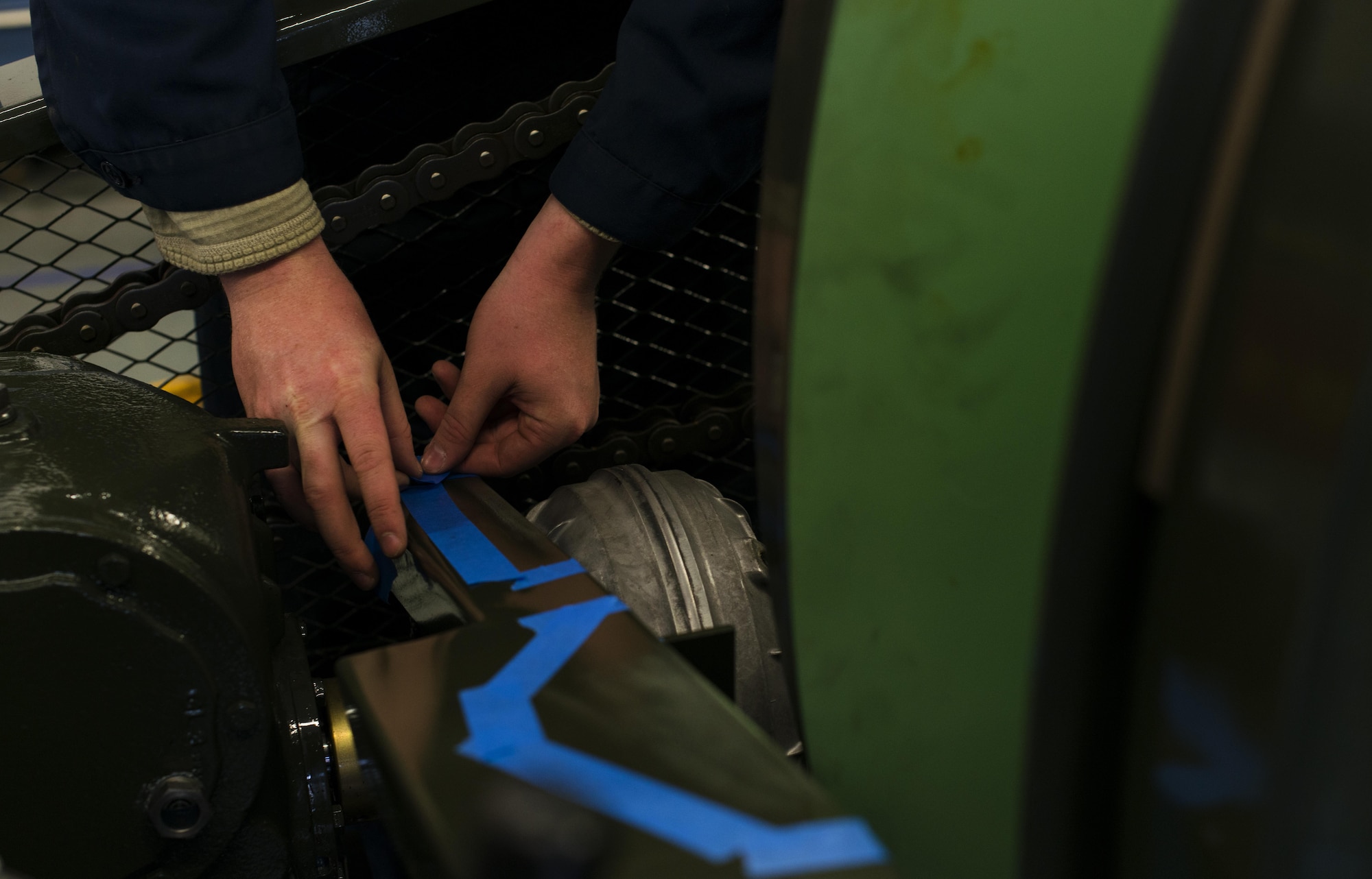 Senior Airman Kevin Glover, 435th Construction and Training Squadron aircraft arresting systems depot technician, tapes around dented or chipped areas on a BAK-12 aircraft arresting system at Ramstein Air Base, Germany, Oct. 12, 2016. Glover taped the areas so they could be painted to help prevent corroding. The 435th CTS overhauls all the arresting systems in U.S. Air Forces in Europe, working on eight systems each year. (U.S. Air Force photo by Senior Airman Tryphena Mayhugh)