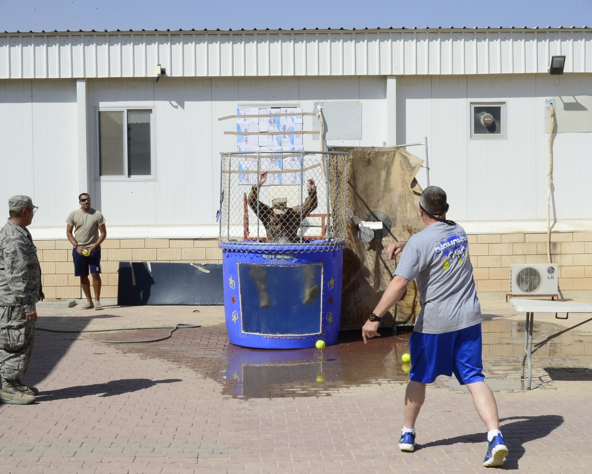 Senior Master Sgt. Don Simmons, 386th Expeditionary Operations Group first sergeant, dunks his boss Col. Charles Stevens, 386 EOG commander, during Rockfest XV Oct. 8, 2016 at an undisclosed location in Southwest Asia. Airmen at the Rock had the opportunity to take their shot at dunking a group of commanders who sat in the dunk to raise morale. (U.S. Air Force photo/Capt. Casey Osborne)