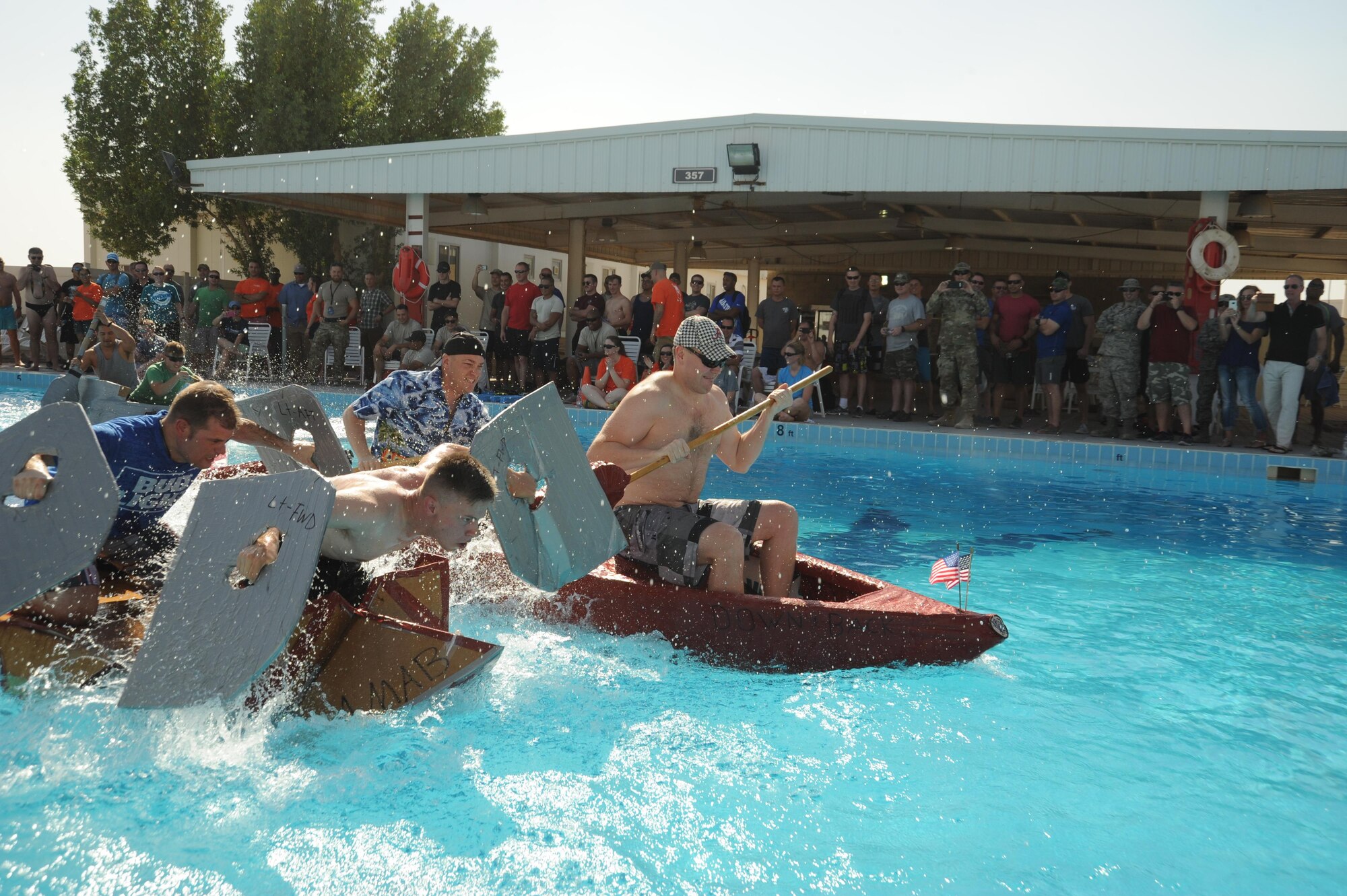 Teams from the 386th Expeditionary Security Forces Squadron, the 46th Expeditionary Reconnaissance Squadron, and the 387th Air Expeditionary Group, battle it out in the championship heat of a boat race Oct. 8, 2016. The race was a part of Rockfest XV where the 46 ERS and their boat “Down and Back” took home the win. (U.S. Air Force photo/Senior Airman Zachary Kee)