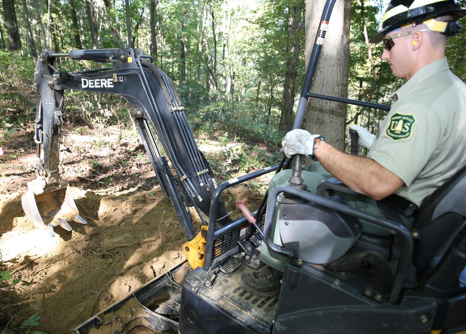 Ohio Army National Guard 1st Lt. Nick Mossbarger of the 216th Engineer Battalion uses an excavator to help construct a section of horse trail as part of his civilian job as a recreation technician for the Wayne National Forest in Southeast Ohio. This summer, Mossbarger was sent west to assist crews fighting wildfires in South Dakota, Colorado and Wyoming. 