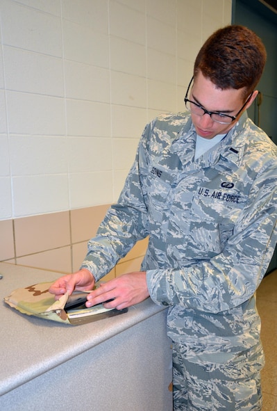 WRIGHT-PATTERSON AIR FORCE BASE, Ohio – 1st. Lt. Jason Goins, a materials research engineer at the Air Force Research Laboratory, shows a prototype of a new flexible body armor plate. The design makes the use of a ceramic ball matrix encapsulated in foam material, which is then backed with multiple layers of polyethylene sheets. (U.S. Air Force photo by Marisa Novobilski/released)

