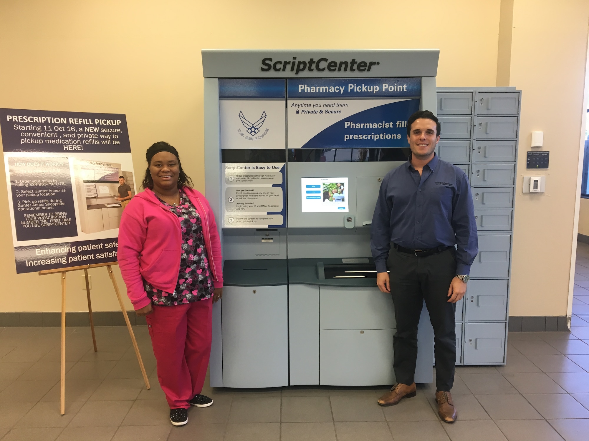 Toia Williams, Maxwell pharmacy, and Ryan Lebowitz, Asteres, pose with Maxwell's new pharmacy kiosk.As of 11 Oct 16, Gunter Annex Pharmacy Refill pickup location has moved from
Building 833 to Gunter Shoppette, Building 814, across from the Barber shop.
Customers who desire to pick up call-in refills at Gunter Annex will use an
automatic kiosk called ScriptCenter for pickup at their convenience.
One-time registration is required prior to accessing the system and patient
(plus family members) may register/enroll anytime.  However, a prescription
number is needed for validation for the first time pickup.  Customers may
access the kiosk anytime, as long as the Gunter Annex Shoppette is open. During the first 2 months, Pharmacy staff will provide an on-site assistance from 0900-1600.  After the initial 2 months, hands-on assistance can be arranged by contacting the pharmacy.  The script Center loading time is between 0900-1000.  At this time, medications required to be stored in a refrigerator prior to dispensing are not available in the kiosk.  Customers will have to arrange a trip to Maxwell Pharmacy for them.  For additional information, please contact pharmacy staff at 953-9333.  (U.S. Air Force photo by Senior Airman William Blankenship)
 