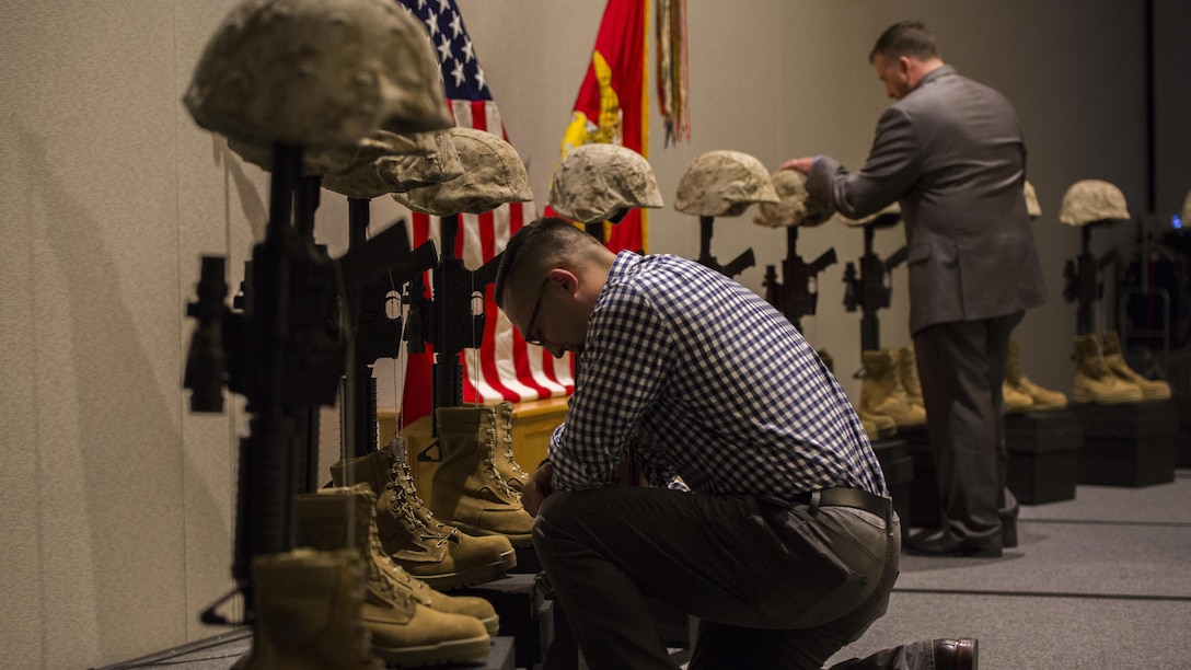 Marines and Sailors from 1st Battalion, 25th Marine Regiment, 4th Marine Division, pay tribute to their fallen brothers at a display of Battlefield crosses during the unit’s 10-year reunion of its deployment to Fallujah, Iraq, in Boston, Oct. 8, 2016. The unit lost 10 Marines and one Sailor during the seven-month deployment in 2006.