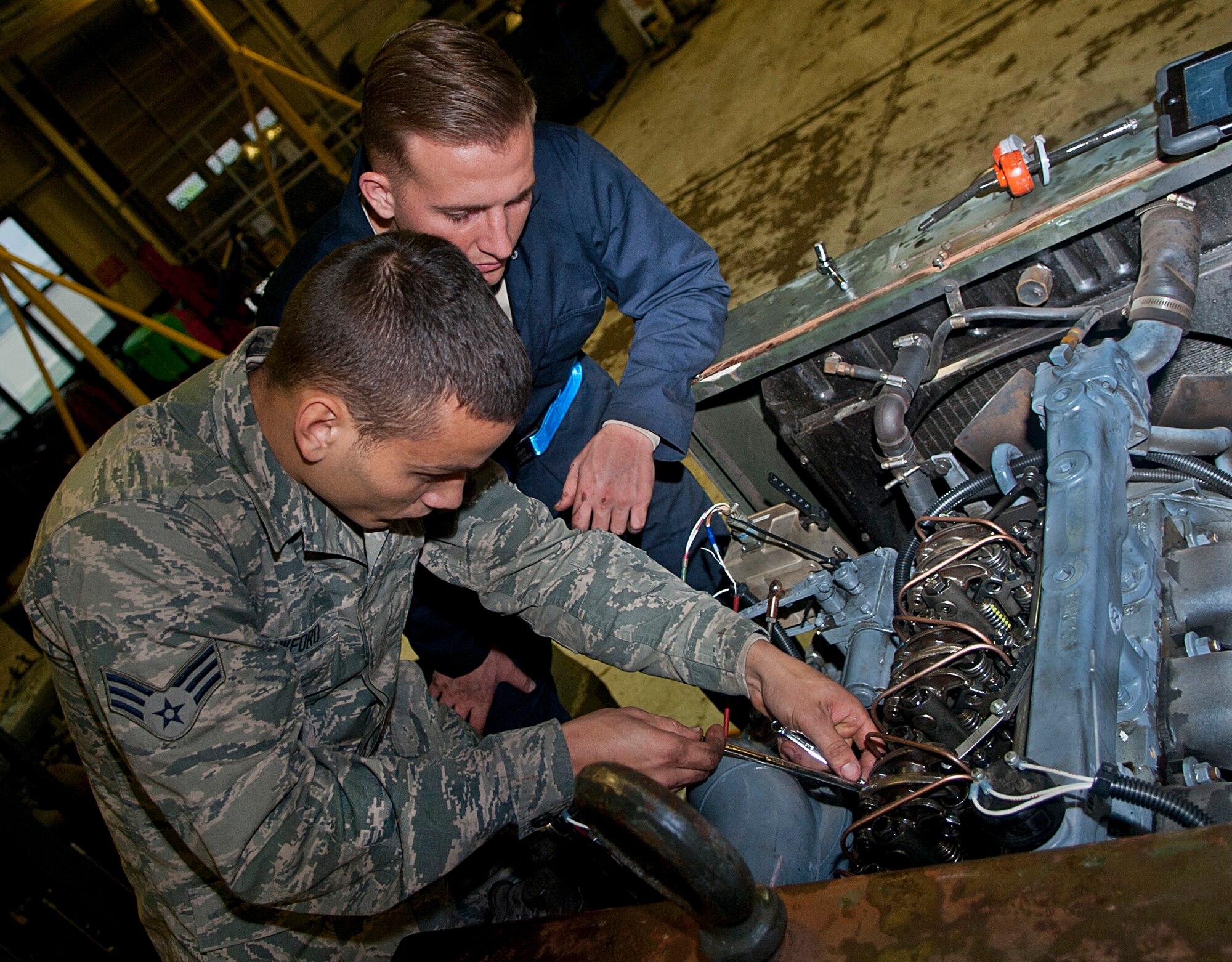 (From left) Senior Airman Cody Crawford, 5th Maintenance Squadron aerospace ground equipment journeyman, and Airman 1st Class Jeremy Graff, 5 MXS AGE apprentice, work on a malfunctioning engine at Minot Air Force Base, N.D., Oct. 5, 2016. The AGE Airmen are responsible for upholding equipment standards by performing routine maintenance and inspections. (U.S. Air Force photo/Airman 1st Class Jonathan McElderry) 