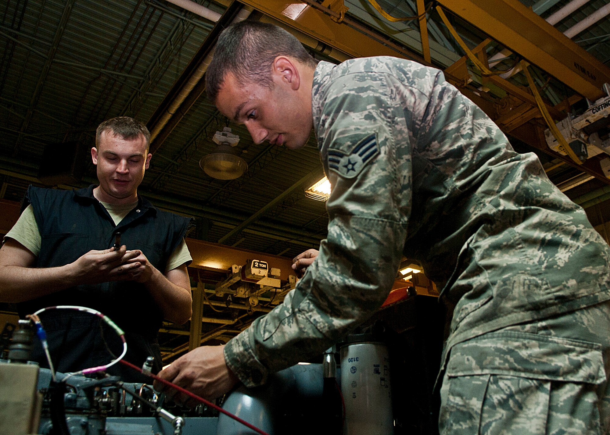 (From left) Senior Airman James Kopp and Senior Airman Cody Crawford, 5th Maintenance Squadron aerospace ground equipment journeymen, check an exhaust cap on a generator at Minot Air Force Base, N.D., Oct. 5, 2016. The AGE Airmen perform a wide variety of tasks, from repairing malfunctioning engines to performing inspections on generators. (U.S. Air Force photo/Airman 1st Class Jonathan McElderry)