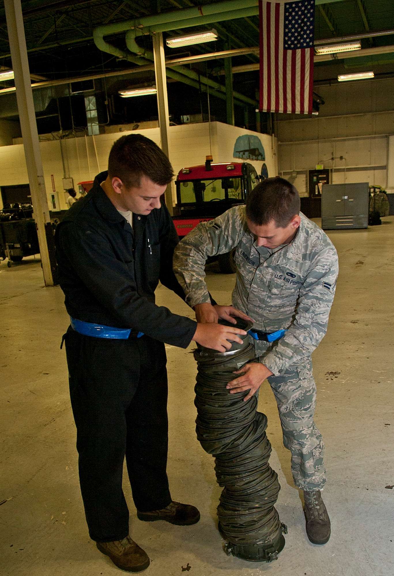 (From left) Airman 1st Class Michael Billen, 5th Maintenance Squadron aerospace ground equipment apprentice, and Airman 1st Class Thomas Erickson, 5 MXS AGE diesel mechanic, connect two air ducts at Minot Air Force Base, N.D., Oct. 5, 2016. Air ducts connect to an MA-3D air conditioner which are used to transfer cold air to aircraft. (U.S. Air Force photo/Airman 1st Class Jonathan McElderry)