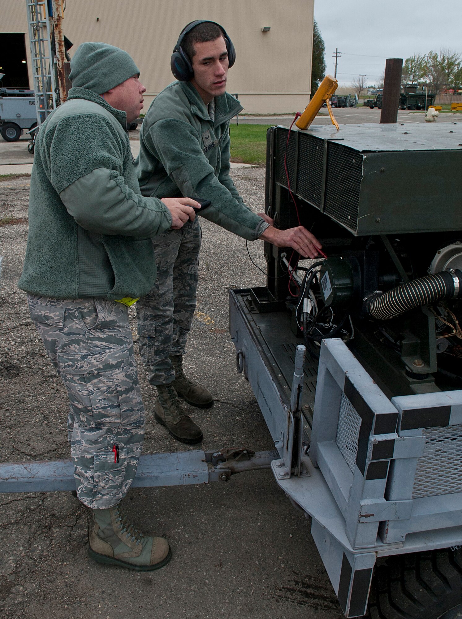 (From left) Staff Sgt. John Dickelman, 5th Maintenance Squadron aerospace ground equipment craftsman and Airman 1st Class Michael Kearns, 5 MXS AGE apprentice, check the voltage on a generator at Minot Air Force Base, N.D., Oct. 5, 2016. The AGE Airmen are responsible for ensuring all generators on base are serviceable. (U.S. Air Force photo/Airman 1st Class Jonathan McElderry)  