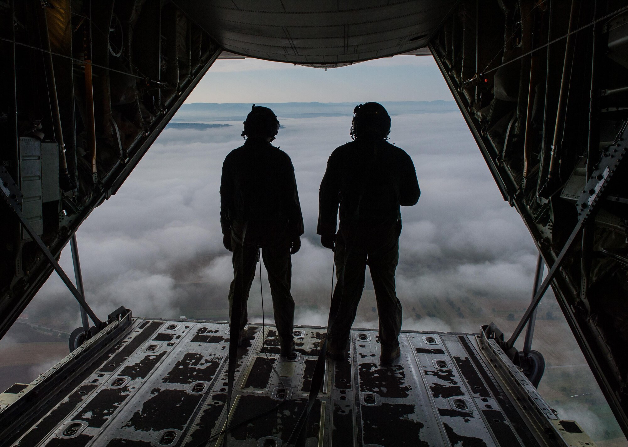 Senior Airman Sarah Meadows and Senior Airman Anthony Oldham, 37th Airlift Squadron loadmasters, look out the back of a C-130J Super Hercules over Germany, Sept. 21, 2016. The 37th AS loadmasters support the U.S European Command and U.S Africa Command by safely loading, unloading, handling, air dropping and delivering aircraft cargo. (U.S. Air Force photo by Senior Airman Nesha Humes)