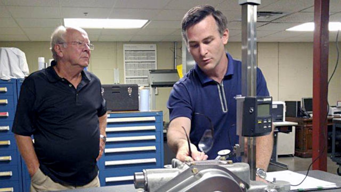 James Vaughn (right), a DCMA Indianapolis quality assurance engineer, explains the protrusion on the oil pump housing issue that prohibited the proper mounting of the M88 engine to contractor quality and engineering personnel. (DCMA photo by Timothy Johnson)