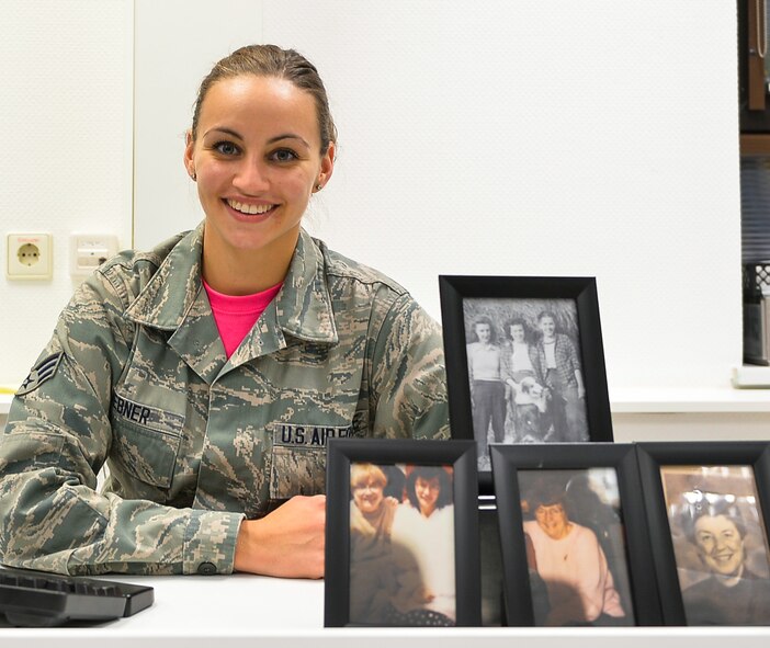 Senior Airman Jordan Hebner, 86th Dental Squadron dental technician, poses with portraits of her grandmother and great-aunts at Ramstein Air Base, Germany. Hebner’s grandmother and great-aunts have been affected by breast cancer, which is the second most common cancer for women in the United States. (U.S. Air Force photo by Airman 1st Class Joshua Magbanua)