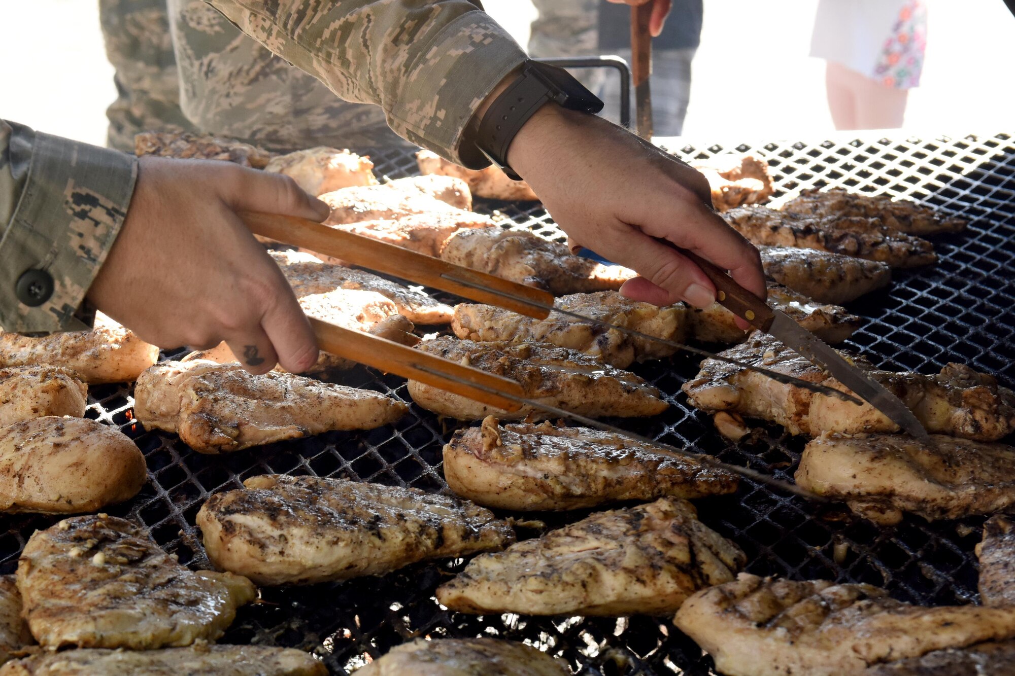 A member of Team Seymour grills chicken to help provide meals to families affected by Hurricane Matthew, Oct. 12, 2016, at Seymour Johnson Air Force Base, North Carolina. More than 100 members from the base volunteered to help deliver hundreds of meals to Airmen in need. 