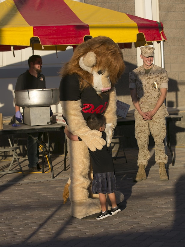 Easton Blanset, 4, son of Chief Investigator Barry Blanset, Provost Marshal’s Office, hugs Daren the Drug Abuse Resistance Education Lion during the Night Out Against Crime at Heritage Park aboard Marine Corps Air Ground Combat Center, Twentynine Palms, Calif., Oct. 4, 2016. (Official Marine Corps photo by Cpl. Thomas Mudd/Released)